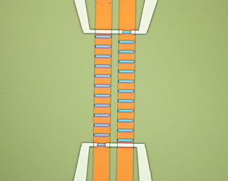 Micrograph of magnetic microfluidic chip developed by the National Institute of Standards and Technology and University of Colorado Boulder. Brief pulses of electrical current in the two orange lines generate a magnetic field to turn individual spin valves (blue bars) on and off, moving a magnetic bead up or down the ladder. Credit: W. Altman/CU and NIST