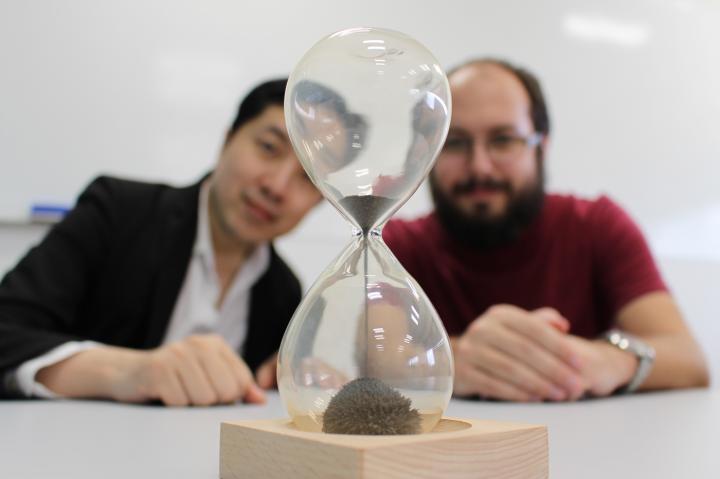 Just as an hourglass needs finer sand to make a more precise measurement of time, a classical computer needs finer time-steps, and in turn more memory, to make more accurate simulations. Quantum effects can provide a work-around, predict researchers Mile Gu (left) and Thomas Elliott (right) in Singapore.