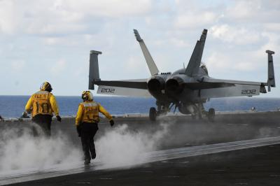 Sailors aboard the aircraft carrier USS Dwight D. Eisenhower (CVN 69) cross the flight deck to prepare to launch an aircraft. Dwight D. Eisenhower is underway conducting training in the Atlantic Ocean.  Credit: US Navy photo by Mass Communication Specialist 2nd Class Julia A. Casper/Released