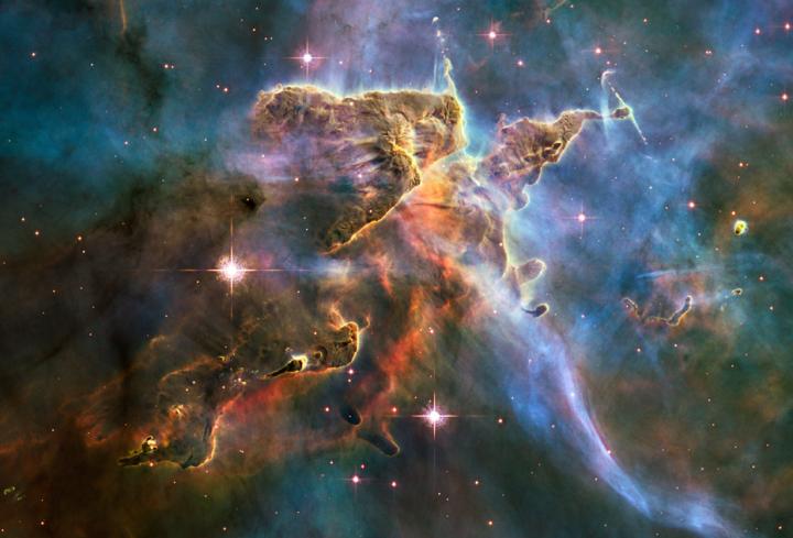 This is a Hubble telescope image of stars forming inside a cloud of cold hydrogen gas and dust in the Carina Nebula, 7,500 light-years away.