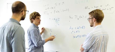 Assistant Professors Aws Albarghouthi and Loris D'Antoni, along with graduate student David Merrell, discuss their work. All photos by Sarah Morton, UW-Madison College of Letters & Science.