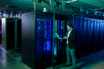 Bruno Jedynak, one of the mathematics and statistics professors who is part of the NSF-funded Research Training Group, stands in front of the Coeus high-performance computing cluster on campus.  CREDIT NashCo Photo