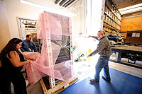 (from left) Marlene Medina, a data specialist I; Jerome Lindsey, data center manager; and Doug Freeman, a data center specialist II, unwrap one of five 1,500-pound computer racks that was unloaded from a moving truck Sept. 14. The IBM equipment will serve as the brain of UW’s Advanced Research Computing Center, located in the Information Technology Center.