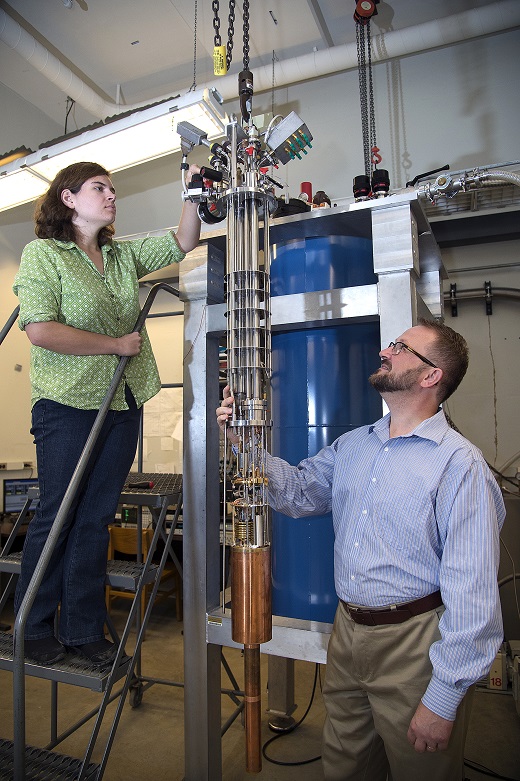 Purdue University professor Gábor Csáthy and graduate student Katherine Schreiber inspect equipment used to cool samples to near absolute zero. The equipment was used in Purdue-led research that led to the observation of an unexpected phase transition in an ultrapure material. (Purdue University photo/Mark Simons) 