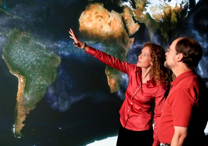 ORNL climate scientist Kate Evans (left) and computer scientist Patrick Worley discuss ways to improve a climate simulation projected on the EVEREST visualization wall. By scaling up climate codes, researchers are able to simulate individual climate components in higher resolution and get more precise results. Photo credit: Jason Richards, ORNL