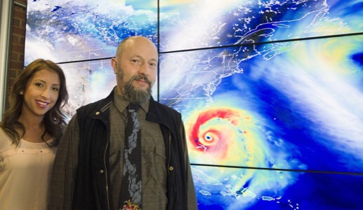 CAPTION NASA tropical meteorologists Oreste Reale and Marangelly Fuentes pose with a hyperwall display of the Global Modeling and Assimilation Office's simulation of a hurricane. CREDIT Credits: NASA/Goddard/Deb McCallum